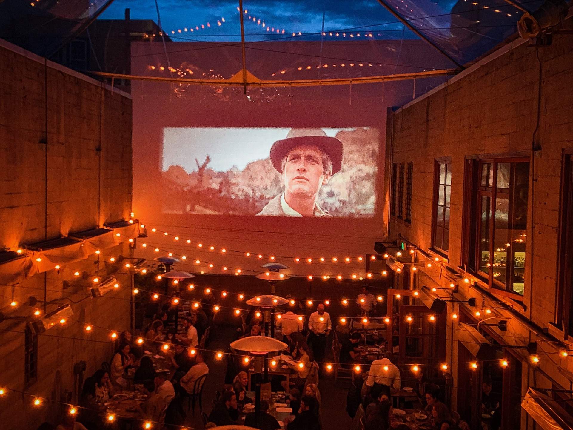 Foreign Cinema Fairy lights, outdoor seats, and a large screen playing a movie at Foreign Cinema in San Francisco