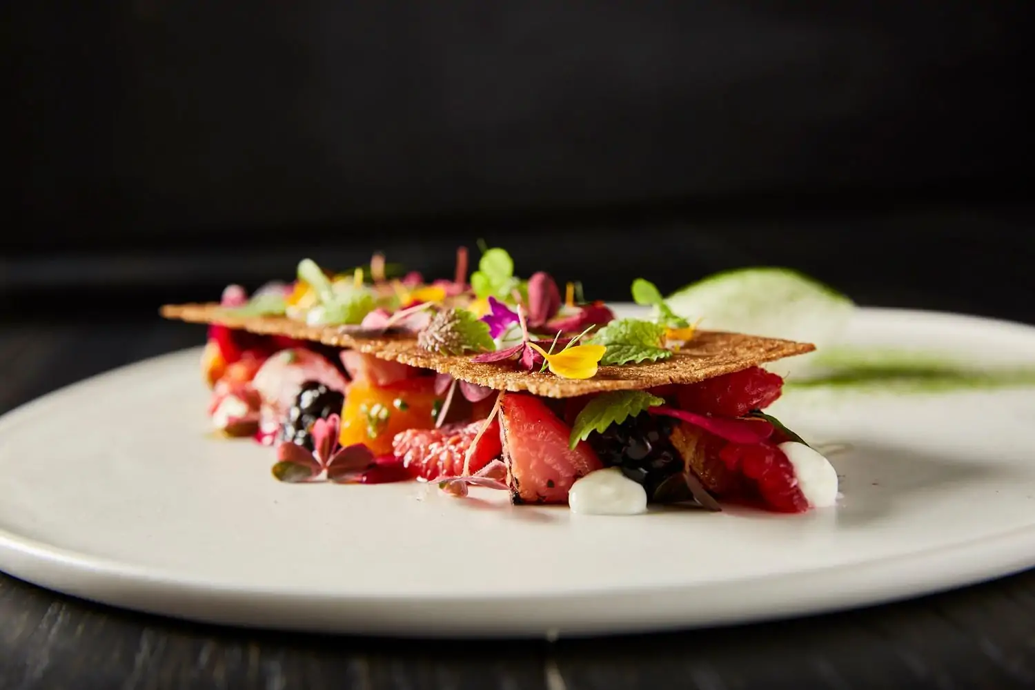 A fruit-based dessert with edible flowers at Miami restaurant Stubborn Seed