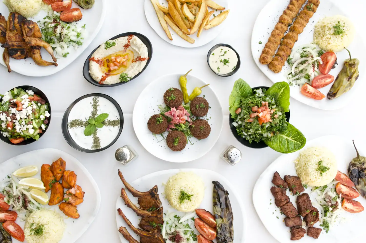 Credit Elena_s Greek Armenian Restuarant.jpg A white table filled with a variety of Middle Eastern dishes, including grilled meats, rice, salads, dips, and bread, at Elena’s Greek Armenian Restaurant, one of the best Mediterranean restaurants Los Angeles available to book on OpenTable.