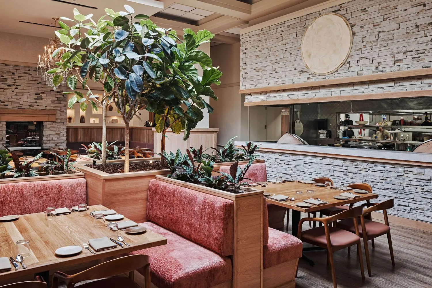 delbar The dining room of Delbar in Atlanta featuring pink cushion-backed banquettes and a tree in the center of the dining room