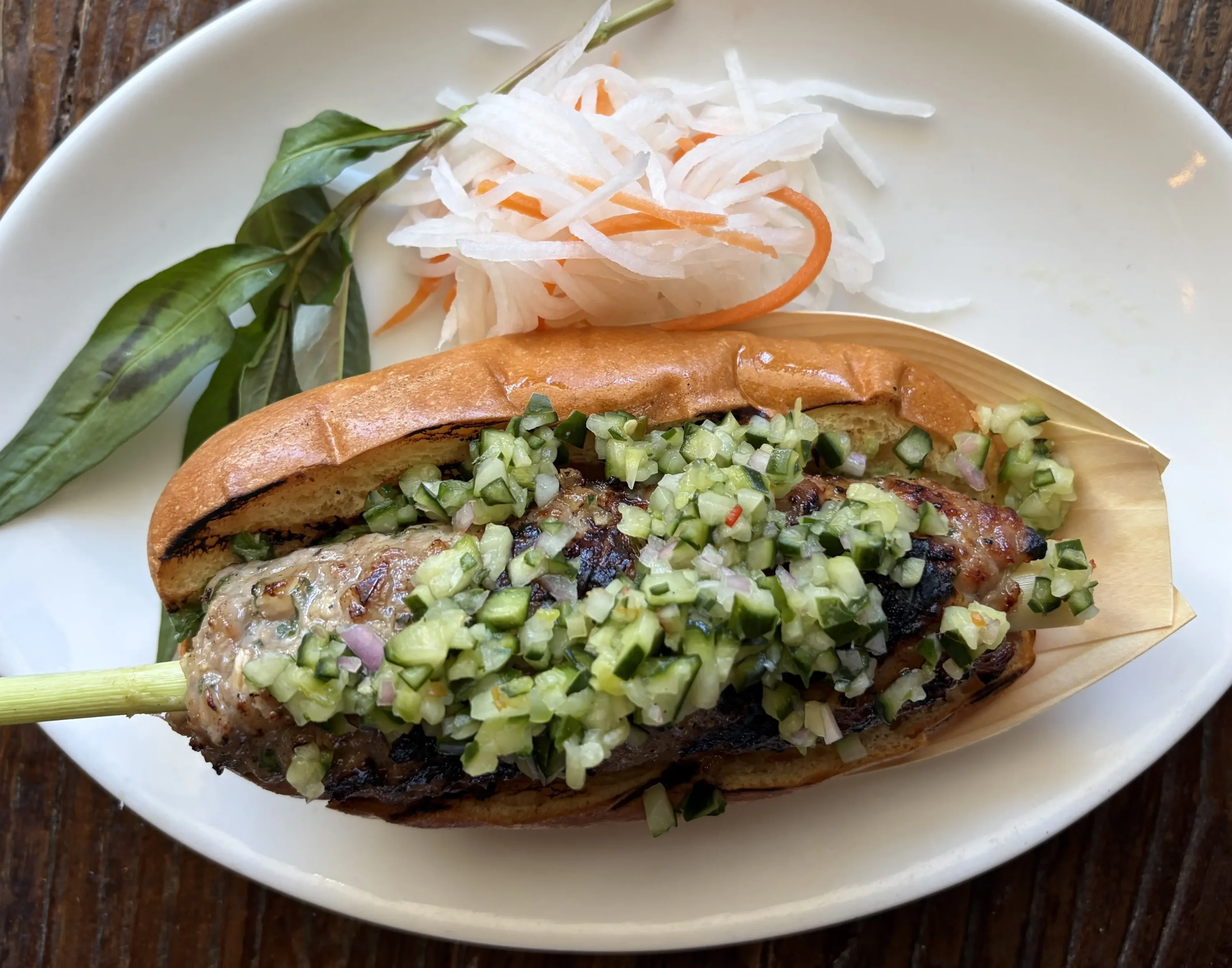 A hot dog on a white plate at the restaurant Asia Live in Santa Clara