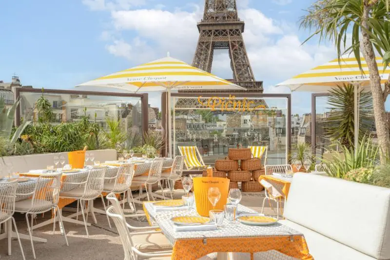 An image of a rooftop bar called Bar les Ombres in Paris with views of the Eiffel Tower in the background