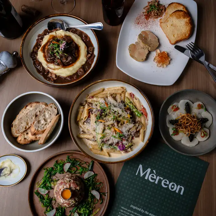 mereon-bistro4 A table laid with dishes including pasta, steak tartare and bread at Merèon Bistro.