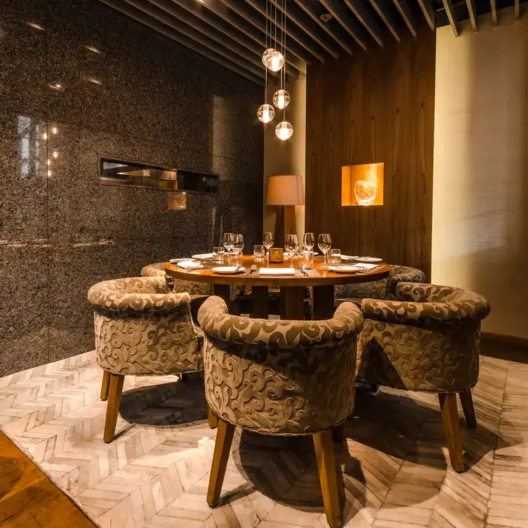1-featured-maison-boulud A table in the Montreal private dining room of Maison Boulud, set for six with wine glasses on a round table.
